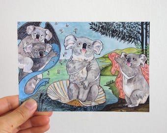 May include: A whimsical watercolor print featuring koalas in a parody of Botticelli's "The Birth of Venus." The artwork depicts koalas in various poses, including one emerging from a seashell. The color palette includes blues, greens, and pinks.