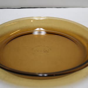 May include: A brown glass pie plate with a slightly raised rim.