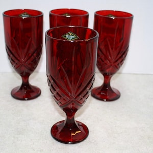 May include: Set of four red glass goblets with a diamond pattern. The goblets have a clear sticker on the bottom that says "Imperial".