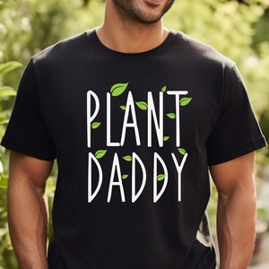 May include: A black t-shirt with the text "PLANT DADDY" in white lettering. Green leaf illustrations surround the text.