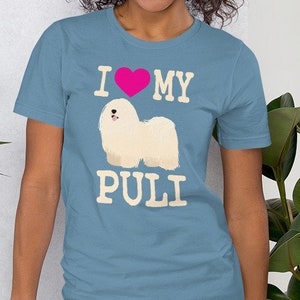 May include: A person wearing a blue t-shirt with a white graphic of a Puli dog and the text "I love my Puli".