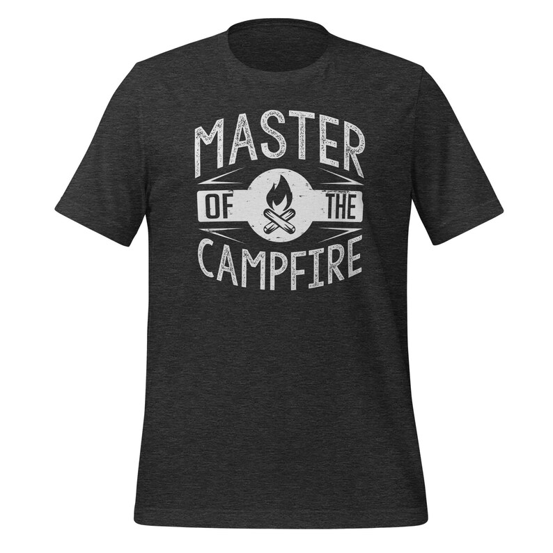 May include: A dark charcoal heather gray short-sleeve t-shirt featuring a white distressed graphic print on the chest. The design includes a central campfire icon inside a circle with the text MASTER OF THE CAMPFIRE printed in a bold font.