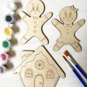 May include: A gingerbread house, gingerbread man, and gingerbread woman wooden craft kit. The kit includes two paintbrushes and five small jars of paint.
