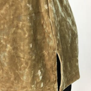 May include: A gold velvet top with a side slit. The fabric has a subtle shimmer.