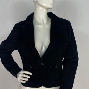 May include: A black velvet blazer with a single button fastening and two flap pockets.