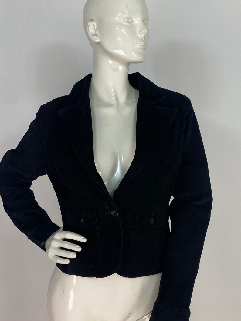 May include: A black velvet blazer with a single button fastening and two flap pockets.