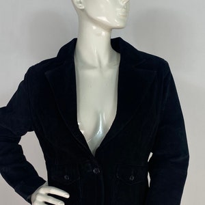 May include: A black velvet blazer with a notched collar, two front pockets, and a single button closure.