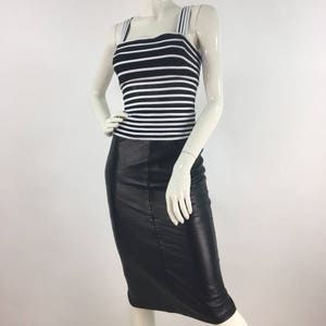 May include: A black and white striped tank top with a black leather skirt. The skirt is knee-length and has a fitted silhouette.