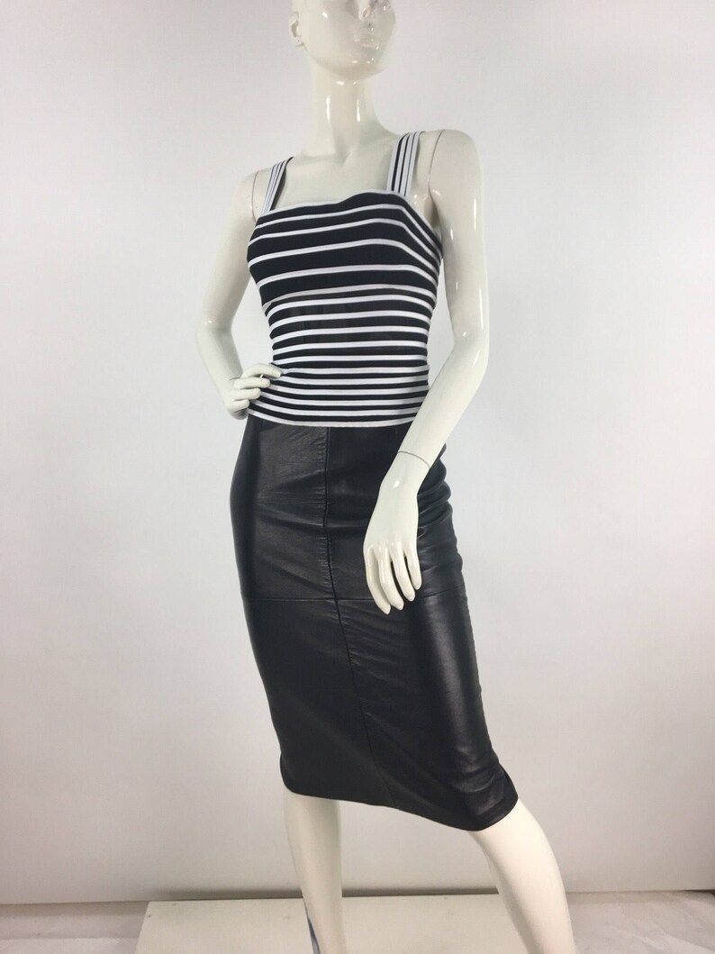 May include: A black and white striped tank top with a black leather skirt. The skirt is knee-length and has a fitted silhouette.