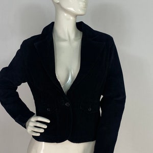 May include: A black velvet blazer with a single button fastening and two flap pockets.