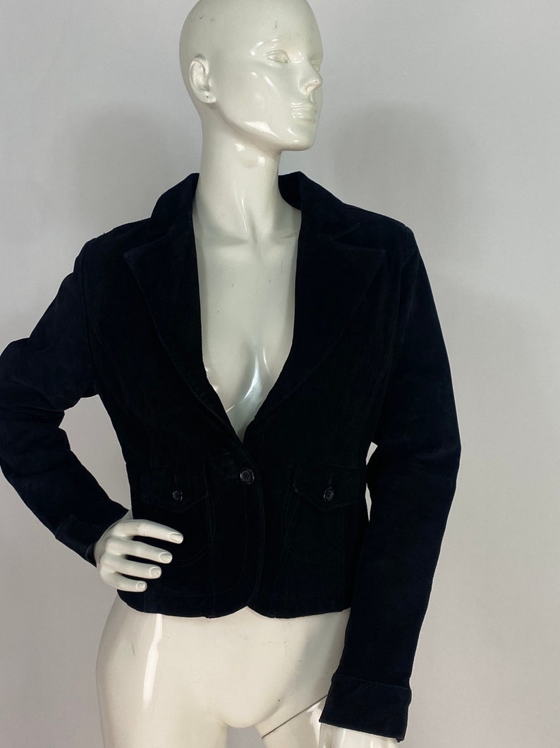 May include: A black velvet blazer with a single button fastening and two flap pockets.