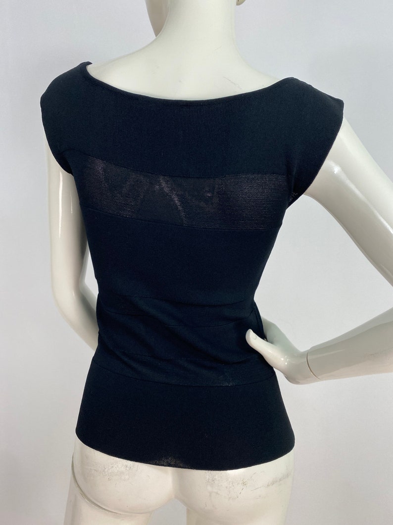 K&ouml;nnte beinhalten: Schwarzes &auml;rmelloses Oberteil mit einem durchsichtigen Einsatz auf dem R&uuml;cken. Das Oberteil ist aus einem dehnbaren Strickstoff gefertigt und hat eine figurbetonte Silhouette.