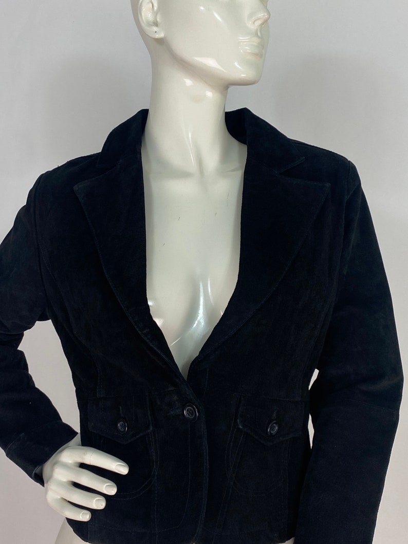 May include: A black velvet blazer with a single button fastening and two flap pockets. The blazer has a classic, tailored fit.