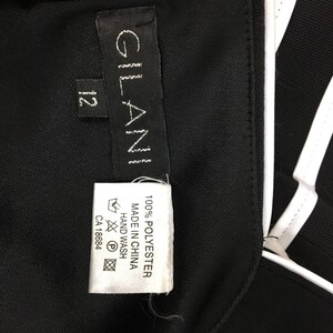 May include: Black and white striped athletic jacket with a white label that says "GLAN" and "100% POLYESTER MADE IN CHINA HAND WASH CA 18684"