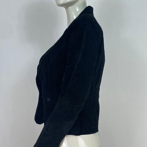 May include: A black velvet blazer with a double-breasted closure and long sleeves.