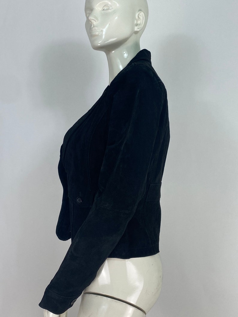 May include: A black velvet blazer with a double-breasted closure and long sleeves.