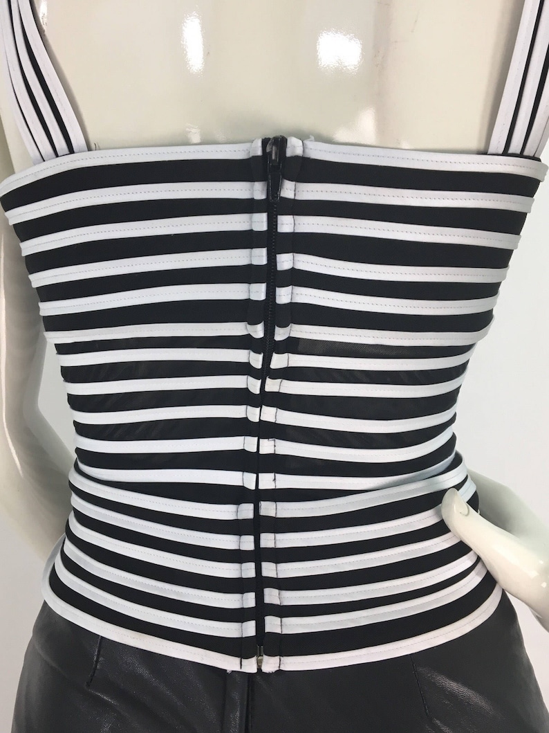 May include: Black and white striped corset top with a zipper down the back.