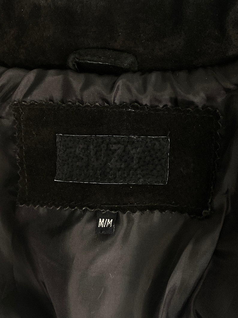 May include: Black suede jacket with a black lining and a label that says "SUZY'S" and "M/M".