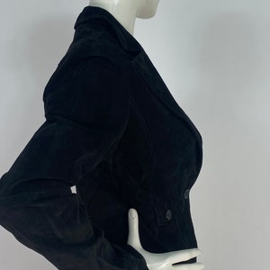 May include: A black suede jacket with a double-breasted closure and long sleeves.