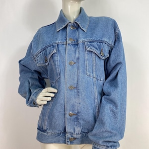 May include: A light blue denim jacket with a button fastening and multiple pockets.
