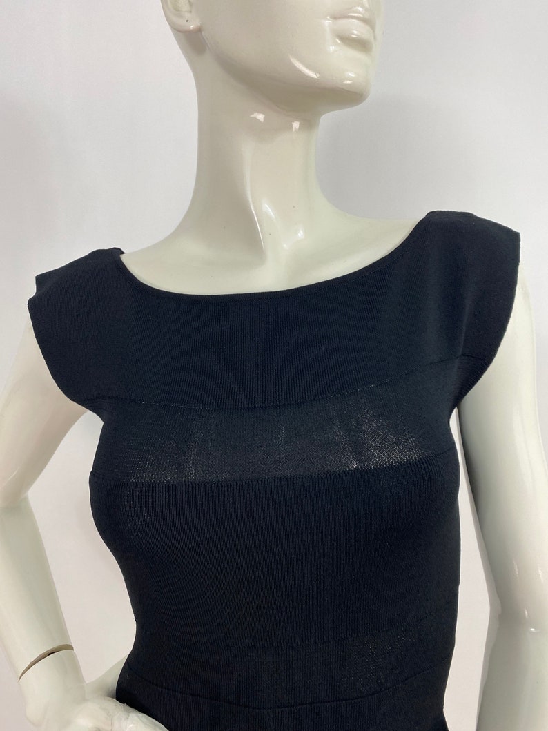 K&ouml;nnte beinhalten: Ein schwarzes, &auml;rmelloses Strickkleid mit Rundhalsausschnitt und figurbetonter Silhouette.