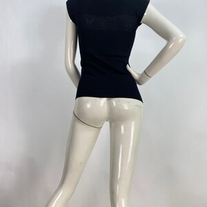 K&ouml;nnte beinhalten: Ein schwarzes, figurbetontes Strickoberteil mit Rundhalsausschnitt und kurzen &Auml;rmeln.