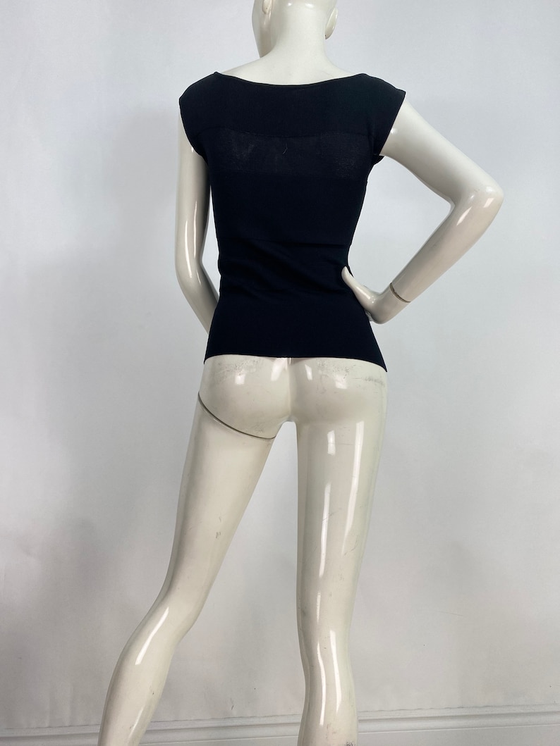 K&ouml;nnte beinhalten: Ein schwarzes, figurbetontes Strickoberteil mit Rundhalsausschnitt und kurzen &Auml;rmeln.
