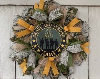 May include: A green, brown, and yellow wreath with a sign that says "Brave and Strong Army". The sign has a silhouette of five soldiers and two dog tags that say "Soldier".