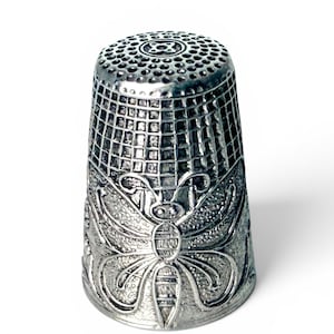 Vintage vingerhoedje van sterling zilver met vlindermotief.