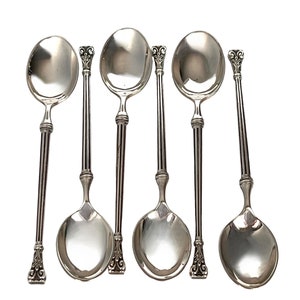 May include: Set of six silver soup spoons with ornate handles. The spoons have a polished finish and are arranged in a row.
