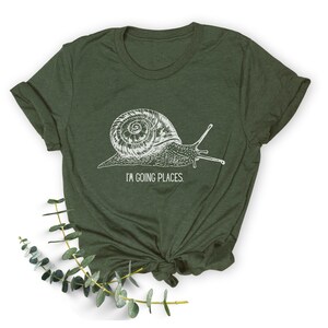 May include: A green t-shirt featuring a white snail graphic and the text "I'm going places."