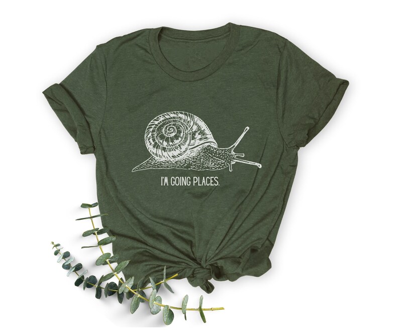 May include: A green t-shirt featuring a white snail graphic and the text "I'm going places."