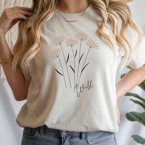 May include: A white t-shirt with a floral design and the word "wild" printed on the front.