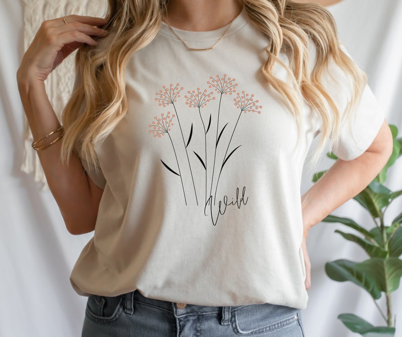 May include: A white t-shirt with a floral design and the word "wild" printed on the front.