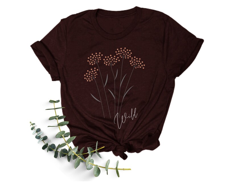 May include: A maroon t-shirt with a graphic of stylized flowers and the word "Wild" printed in white.