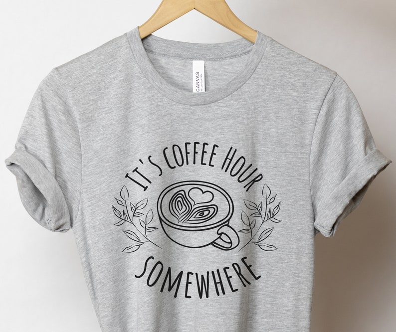May include: Gray t-shirt with a black graphic of a coffee cup with the text "It's coffee hour somewhere".