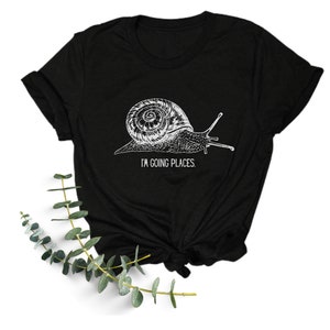May include: Black t-shirt with a white graphic of a snail and the text "I'm going places."