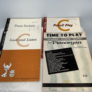 May include: Four vintage music books with colorful covers. The books are titled "Piano Technic", "Look and Listen", "Pencil Play", and "Time to Play". The "Time to Play" book is for the Pianorgan and features a list of songs.