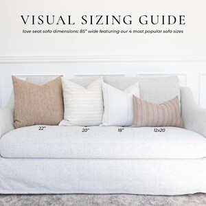May include: A light gray slipcovered loveseat sofa measuring 85 inches wide, displayed with four decorative throw pillows in varying sizes labeled 22, 20, 18, and 12x20 inches. The text VISUAL SIZING GUIDE is printed at the top of the image.