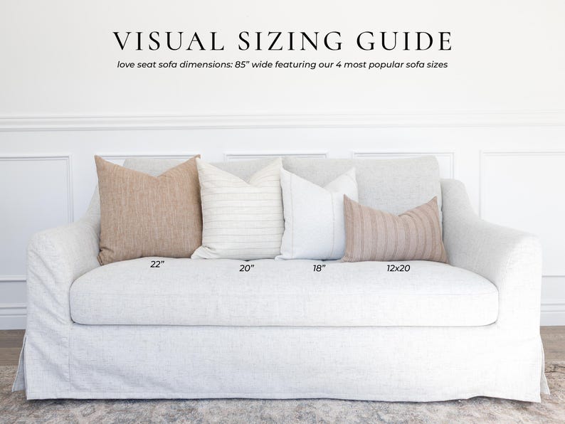 May include: A light gray slipcovered loveseat sofa measuring 85 inches wide, displayed with four decorative throw pillows in varying sizes labeled 22, 20, 18, and 12x20 inches. The text VISUAL SIZING GUIDE is printed at the top of the image.