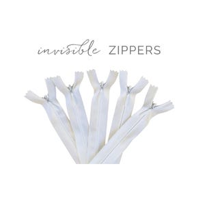 May include: A collection of white invisible zippers, arranged in a fan shape against a white background. The text "invisible ZIPPERS" is displayed in a delicate font above the zippers. These zippers are ideal for sewing projects.