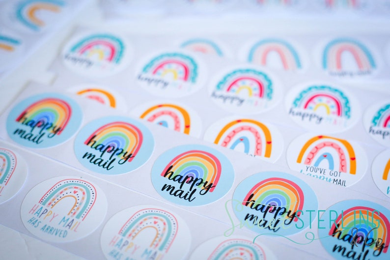 May include: Round stickers with rainbow designs and the words "happy mail" in black. The stickers feature colorful rainbows in various styles, with some having the text "Happy Mail Has Arrived" and "You've Got Mail".