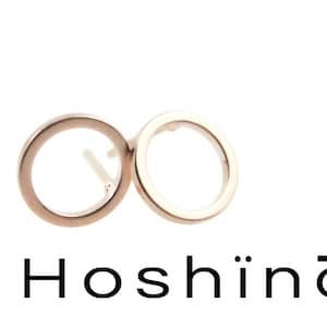 Peut inclure: Une paire de boucles d'oreilles rondes en or rose. Les boucles d'oreilles sont simples et élégantes.