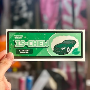 May include: A green sticker with the text "IS-CHEW" and "MIDNIGHT MATCHA". The sticker features a green car graphic and two green leaves. The top of the sticker has Japanese text and a white border.