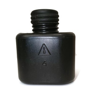 May include: Black plastic bottle with a threaded cap and a warning symbol. The bottle has a number "4" printed on it.