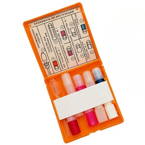 May include: An open orange medical kit with various vials and a printed instruction sheet. The kit contains several small, colourful vials and a clear ampule. The instruction sheet has diagrams and Russian text.