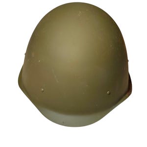 Op de afbeelding: Een matte olijfgroene helm in militaire stijl met een gladde, ronde koepelvorm. De helm heeft een eenvoudig, onversierd buitenoppervlak met kleine, cirkelvormige klinknagels aan de zijkanten, wat zorgt voor een strak en functioneel ontwerp.