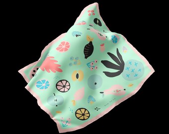 May include: A square silk scarf with a light green background and a repeating pattern of colorful fruit illustrations. The scarf has a pink border and features lemons, peaches, and other fruit designs.