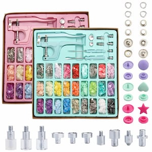 Könnte beinhalten: Ein Set mit bunten Druckknöpfen und Werkzeugen zum Anbringen an Stoff. Das Set enthält eine Vielzahl von Farben, Größen und Formen von Druckknöpfen sowie ein Werkzeug zum Anbringen. Die Werkzeuge sind aus Metall und haben einen Griff für eine einfache Verwendung.