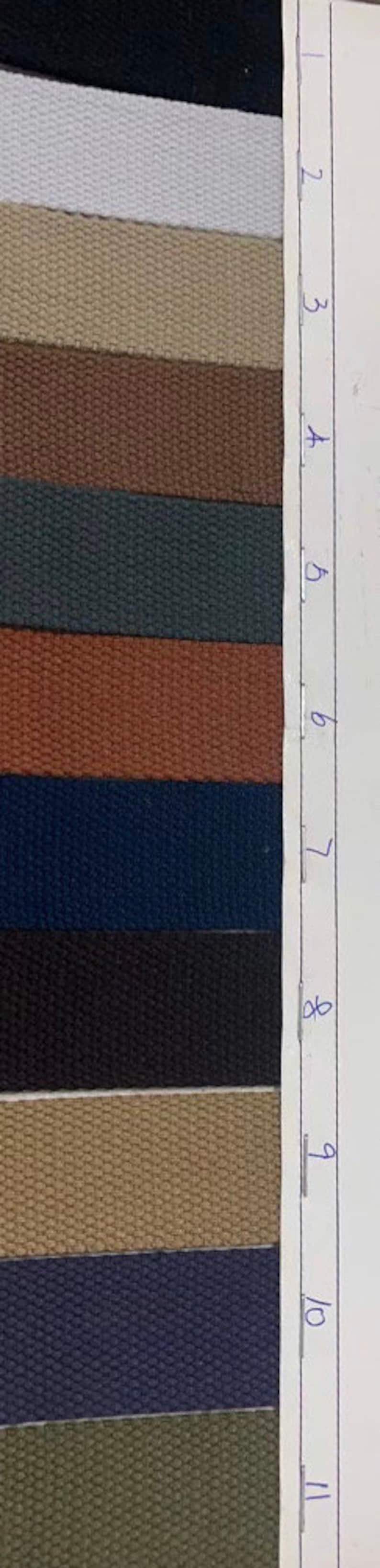May include: A sample card of 11 different colors of webbing. The colors are white, beige, brown, dark green, rust, navy blue, black, tan, dark blue, and olive green.